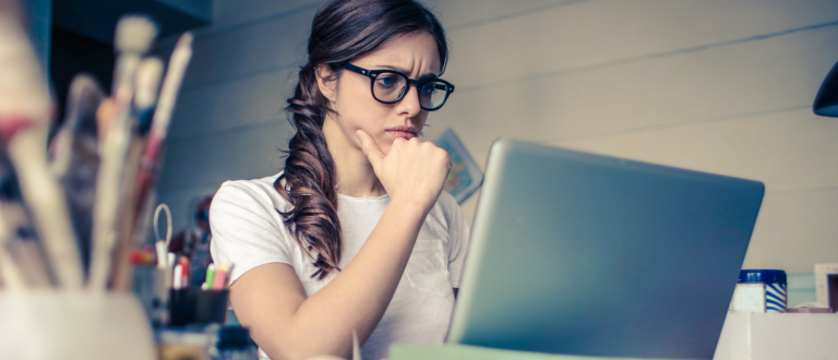 Woman looking at computer with a confused expression