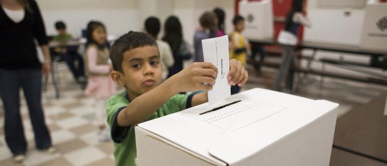 Child placing vote in ballot box