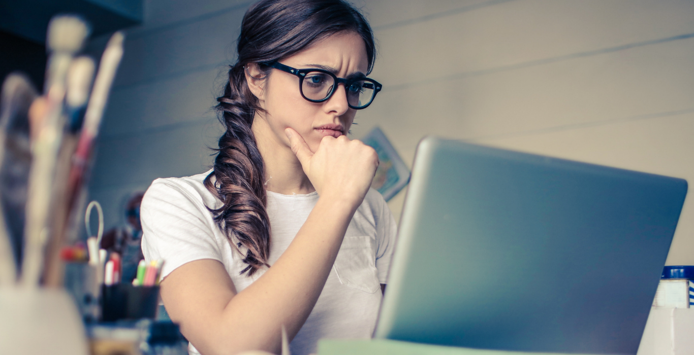 Woman looking at computer with a confused expression