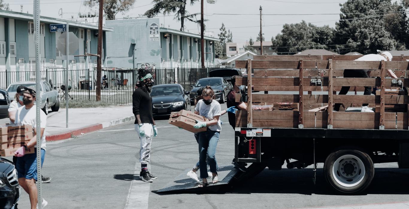 volunteers with masks unloading truck