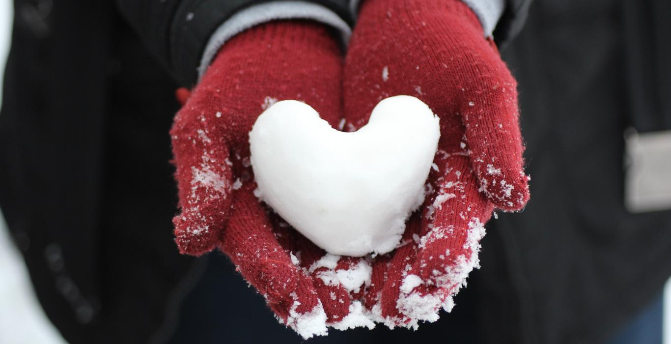 Heart shaped snowball in gloves