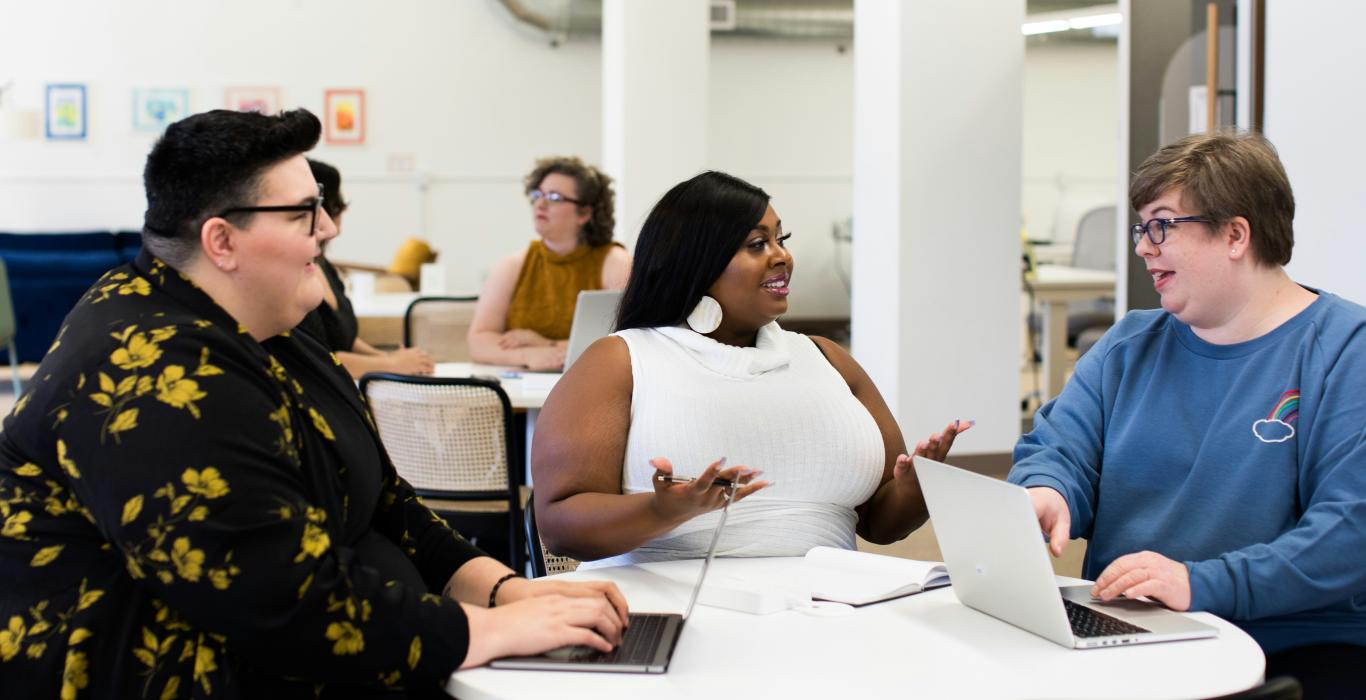 Group of employees in a modern, bright open office working on computer