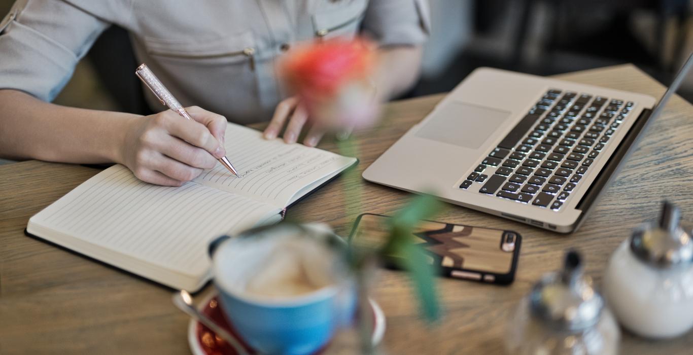 Person writing in notepad