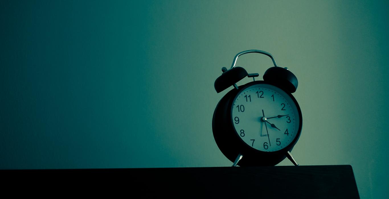 Alarm clock on blue background