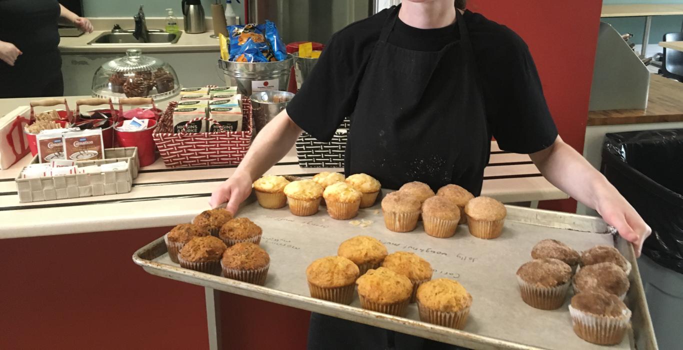 Woman holding tray of muffins